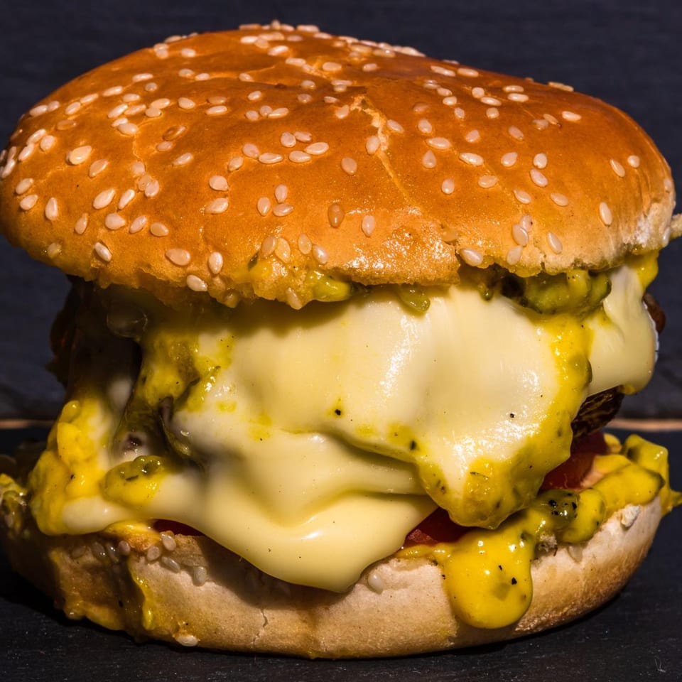 A Jean's Diner burger with melted cheese, relish, and a sesame seed bun.